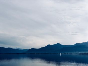 Scenic view of lake by mountains against sky