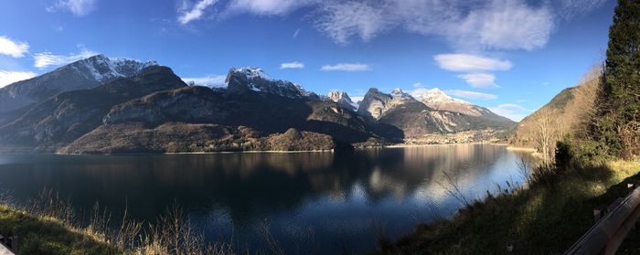 Scenic view of lake by mountains against sky