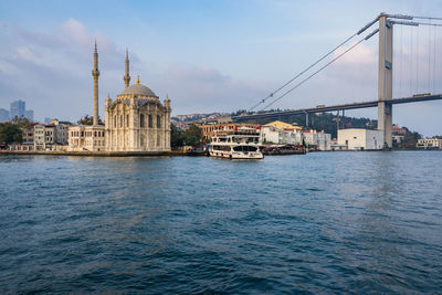 View of buildings by sea against sky in city