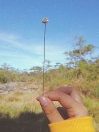 Midsection of person holding umbrella against sky