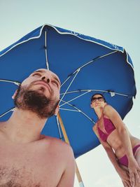 Low angle view of couple against umbrella