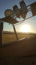 Tilt image of road amidst field against sky during sunset