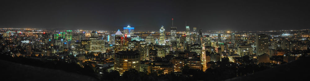 Illuminated cityscape against sky at night