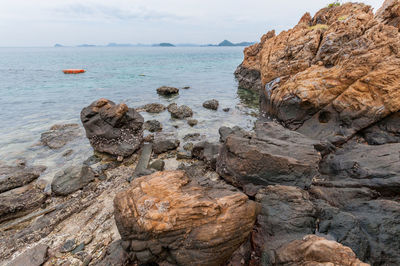 Rock formation on beach against sky