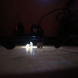 Close-up of lit candle on table in darkroom