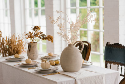 Thanksgiving table setting with pumpkins and dried flowers, autumn decorations