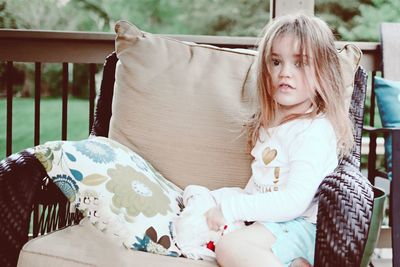 Portrait of girl sitting on bed