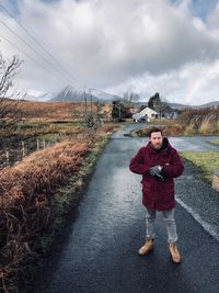 Man standing on road against sky during winter