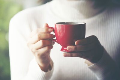 Woman hand holding cup of coffee