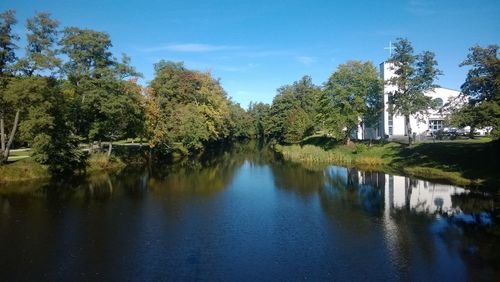 Scenic view of lake by trees against sky