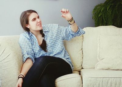 Young woman sitting on sofa