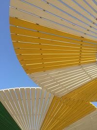 Low angle view of yellow umbrella against clear sky