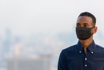 Portrait of young man looking away wearing face mask