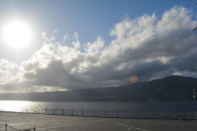 Sun shining through clouds over sea