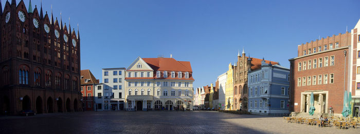 Panoramic shot of historic buildings in city against clear blue sky