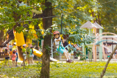 Rear view of boy on plants against trees