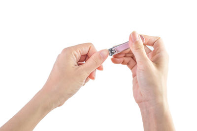 Cropped image of person cutting fingernails over white background