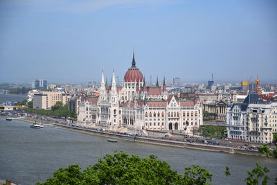 River amidst buildings in city against sky