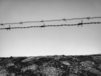 Close-up of barbed wire against clear sky