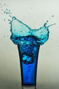 Close-up of water drops on glass against white background