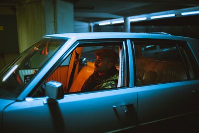 Side view of man sitting in car