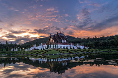 Reflection of building on lake during sunset