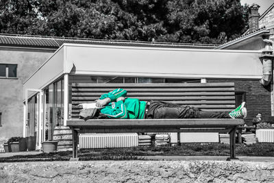 Man sitting on bench against trees