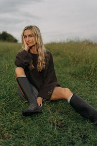 Portrait of young woman sitting on field