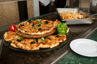 Photo of a sliced pizza on a buffet table