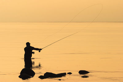 Fly fishing in the sunset at the sea