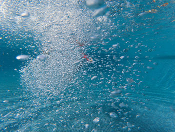 Girl swimming underwater in swimming pool