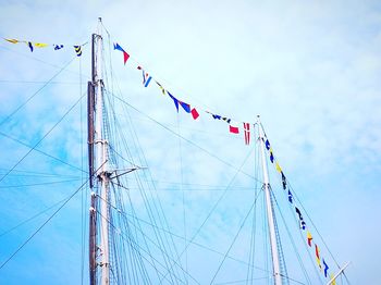 Low angle view of flags hanging on pole against sky