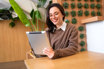 Portrait of young man using laptop while sitting on table