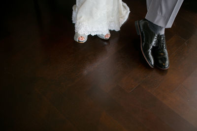 Low section of couple on hardwood floor