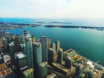 High angle view of city by sea against sky