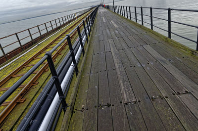 Footbridge over river against sky