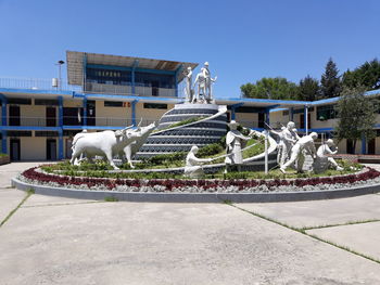 Statue by fountain against sky