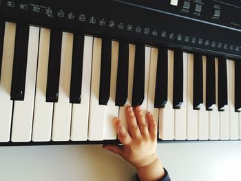 Cropped image of baby boy playing piano