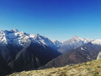 Scenic view of snowcapped mountains against clear blue sky