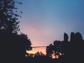 Low angle view of silhouette trees against sky at sunset