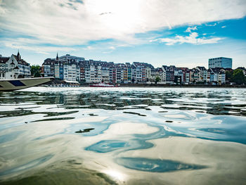 River by buildings in city against sky