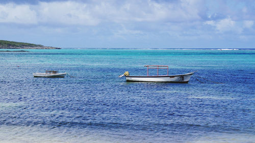 Fishing boat in sea against sky