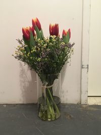 Close-up of flowers in vase against wall