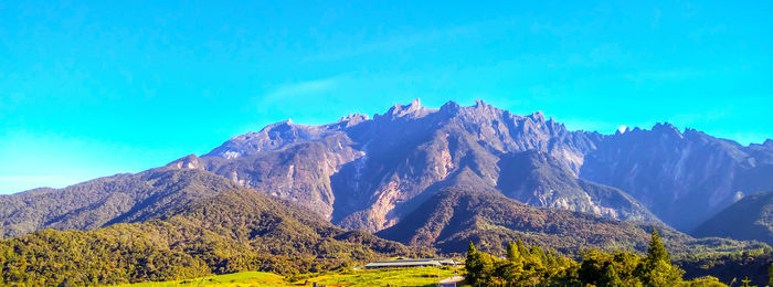 Panoramic view of mountains against blue sky