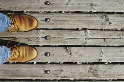 Low section of person standing on wooden floor