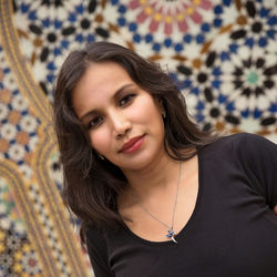 Tilt portrait of woman against mosaic wall