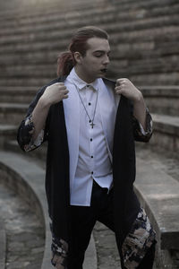 Young male model standing on steps during sunset