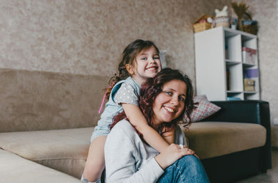 Portrait of a smiling young woman sitting on sofa