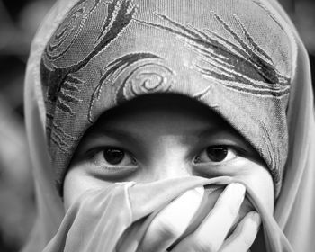 Close-up portrait of girl covering face standing outdoors