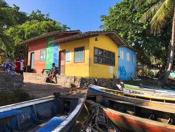 Boats moored in canal by building against sky